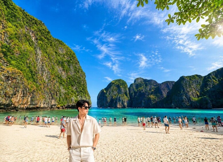 A beach with clear turquoise water and lush green cliffs. 1