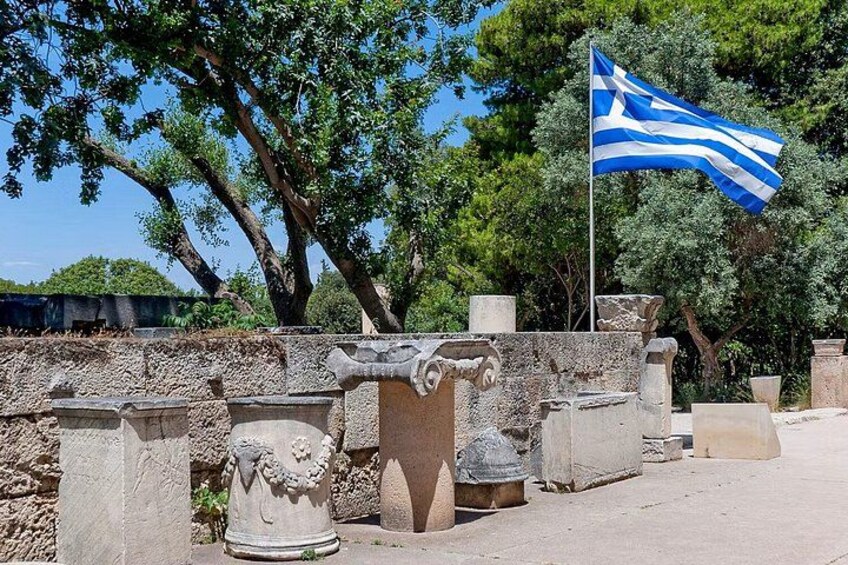 Ancient ruins with columns and a Greek flag. 3