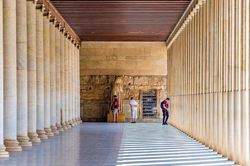 A corridor with columns, a tiled floor, and a wooden ceiling. 5
