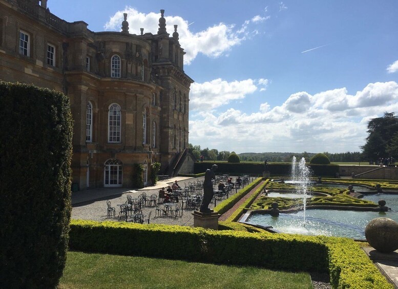 A historic building with a formal garden and a fountain. 2