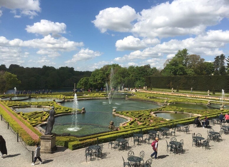 A formal garden with fountains, manicured hedges, and outdoor seating areas. 4