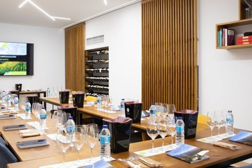 A conference room with tables set for a meeting, each with water bottles and wine glasses. 3