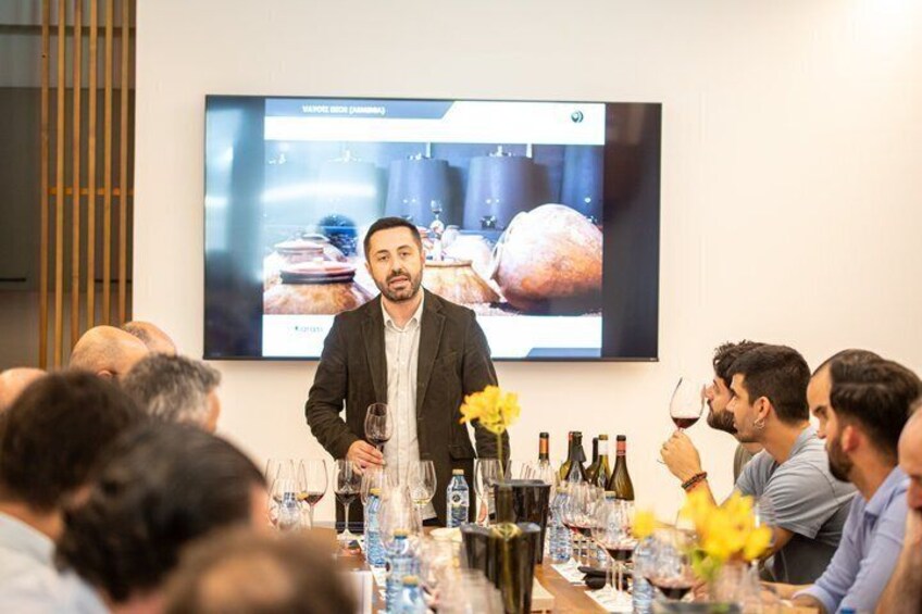 A man presenting in front of a screen with food and wine. 2