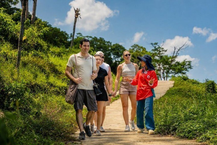 A group of people walking on a dirt path surrounded by greenery. 1
