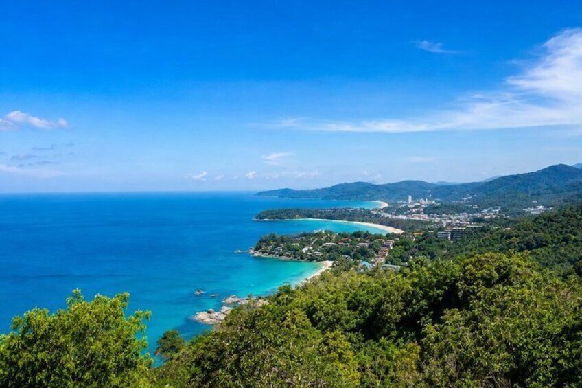 A coastal landscape with a clear blue sea, a small island with a beach, and a forested area. 4