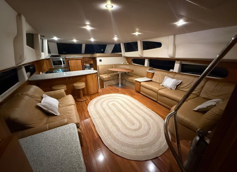 A yacht interior with a dining area, a kitchen, and two sofas. 2