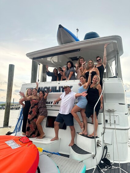 A group of people on a boat with 'BAY' written on the side. 4