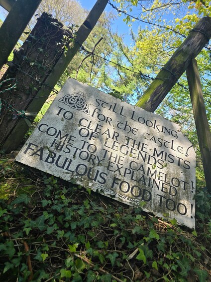 A weathered sign with text about a castle, legends, and food. 2