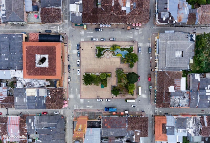 An aerial view of a city intersection with buildings, a central plaza, and a swimming pool. 4