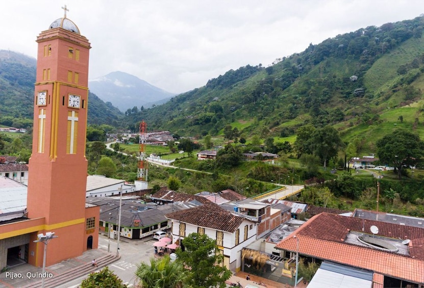 A clock tower, a church, and a mountainous landscape with a small town. 2