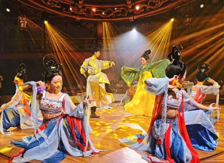 A traditional dance performance with dancers in colorful costumes on a stage with ornate architecture. 3