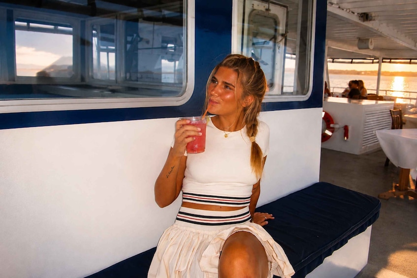 A person sitting on a bench inside a train carriage. 5