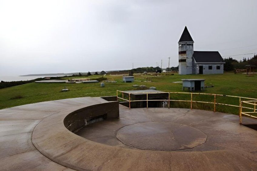 A concrete amphitheater with a church in the background. 1