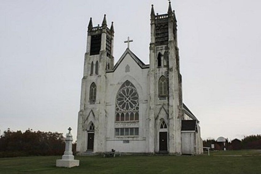 A large white church with two towers and a large arched window. 3