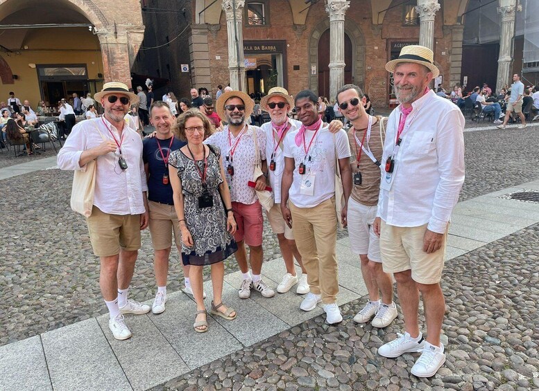 A group of people standing in a cobblestone square with historic buildings in the background. 1