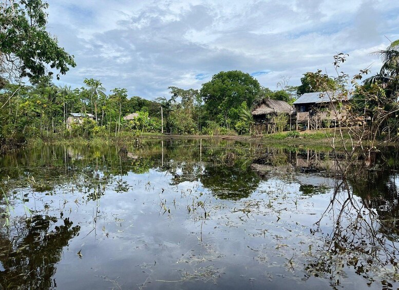 A calm lake with reflections, surrounded by lush greenery and traditional houses. 5