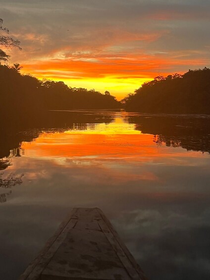 A sunset over a calm river with a wooden dock in the foreground. 3