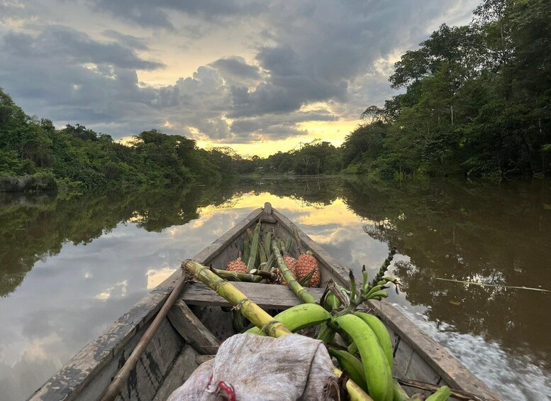 A wooden boat on a calm river with reflections of trees and a cloudy sky. 1