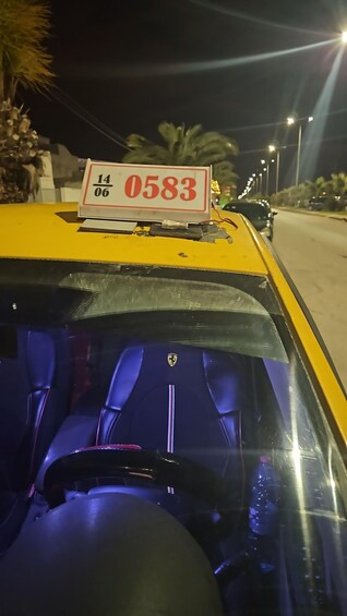 A yellow taxi with a sign reading '14/06 0583' on the roof. 2