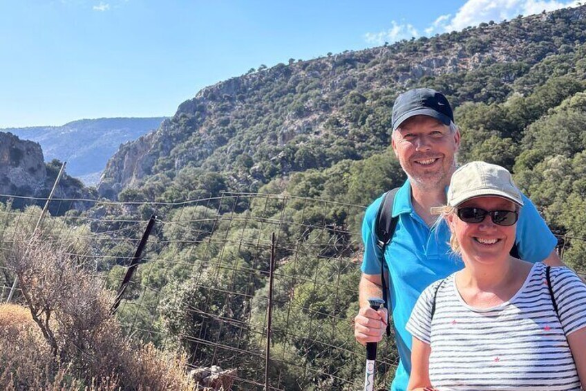A couple standing on a hill with a mountainous landscape in the background. 1