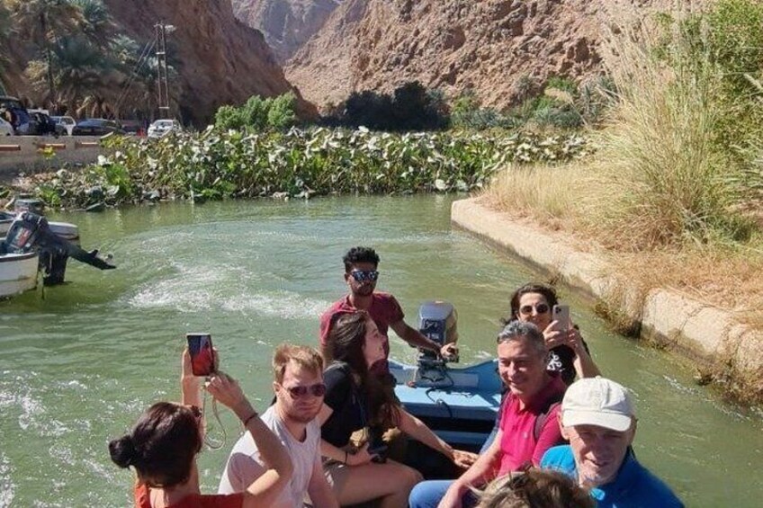 A group of people on a boat in a river with a rocky landscape in the background. 3