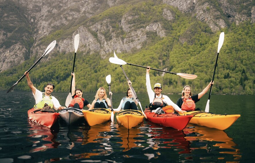 A group of people kayaking on a calm lake with a mountainous backdrop. 5