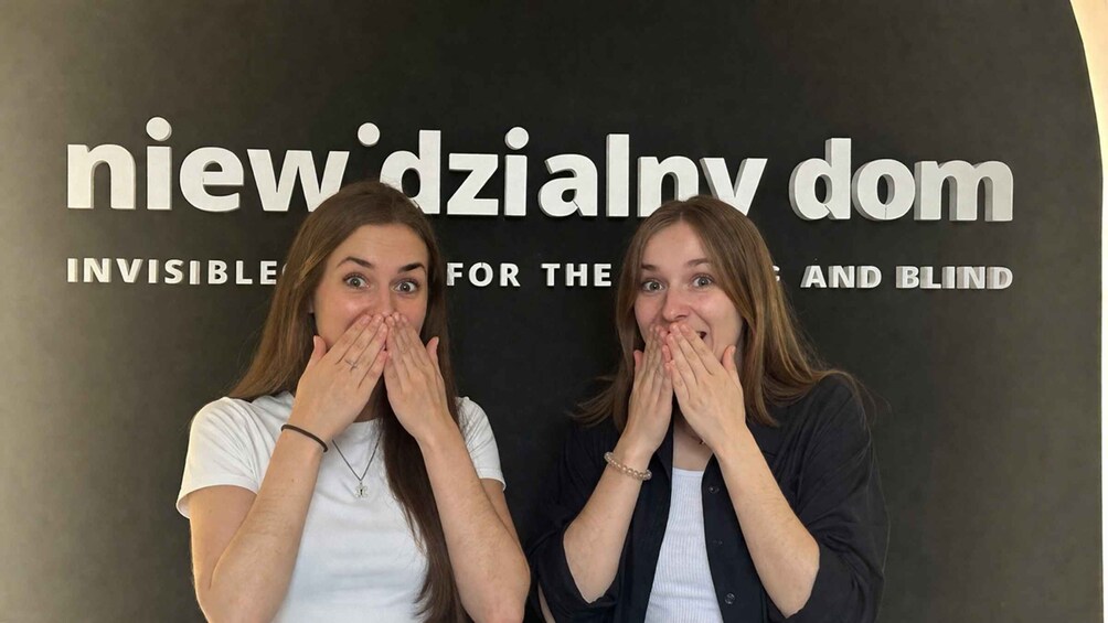 Two people in front of a sign with text. 3