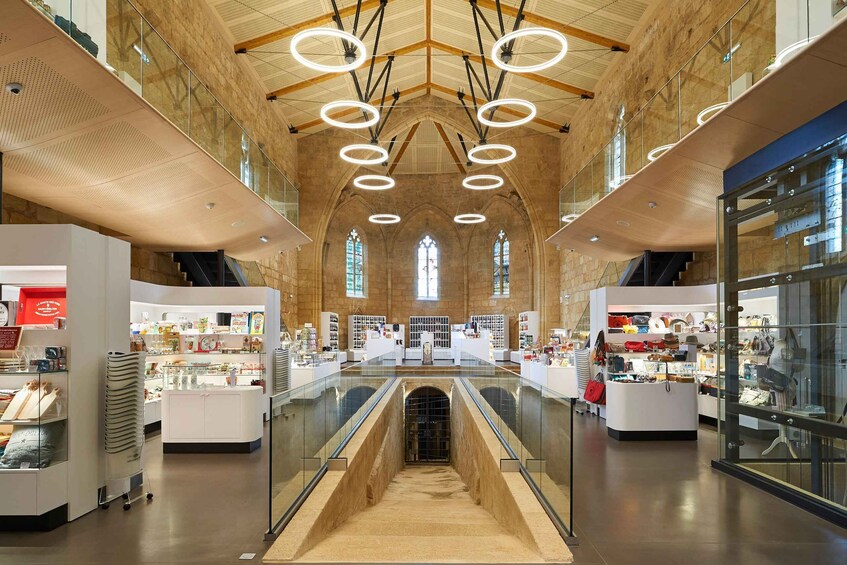 A spacious shopping mall with high ceilings, circular lighting fixtures, and a central walkway. 2