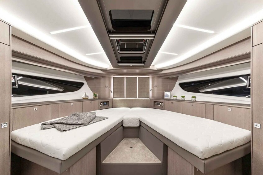 A modern, well-lit interior with a central bed, storage cabinets, and a skylight. 5