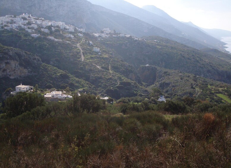 A mountainous landscape with white buildings nestled among the hills. 1