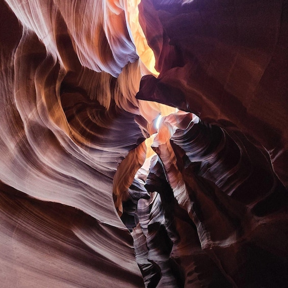 A canyon with smooth, curved rock formations and a narrow passageway. 3