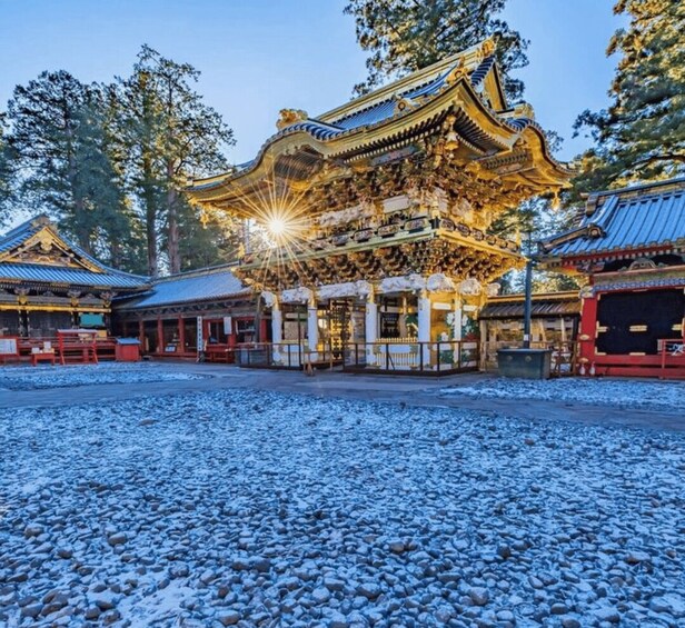 A traditional Japanese temple with ornate golden architecture, surrounded by snow-covered ground and trees. 2