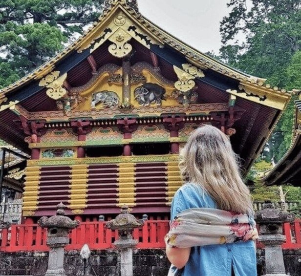 A person standing in front of a traditional temple with ornate architecture. 5