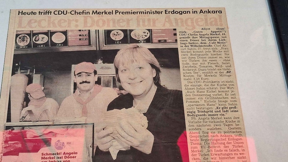 A newspaper article with a photo of a woman and a man in a café setting. 2