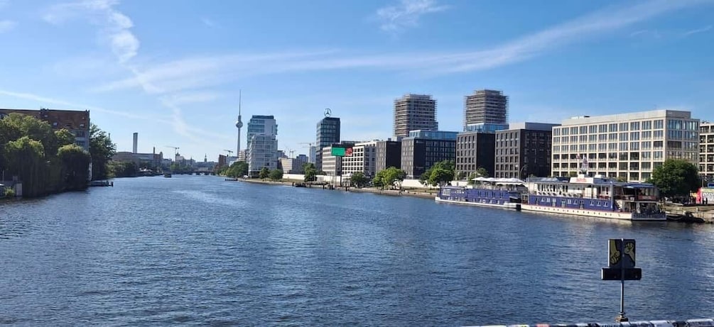 A river with a cityscape on the opposite bank, including modern buildings and a bridge. 3
