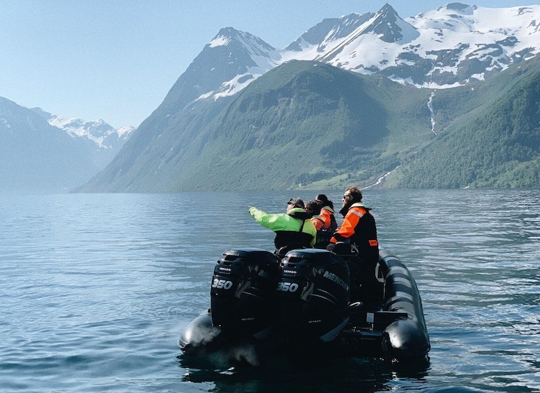 A group of people on an inflatable boat with a mountainous landscape in the background. 5