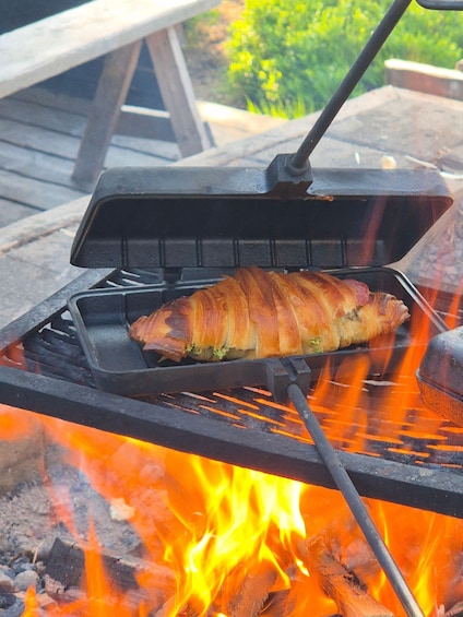 A whole roasted pig on a grill over an open fire. 5