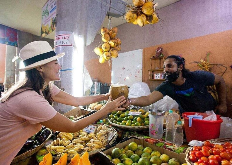 A market stall with coconuts, bananas, and tomatoes. 3