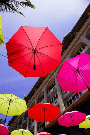 A row of colorful umbrellas against a building backdrop. 2