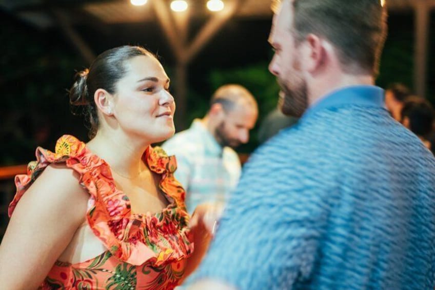 Two people dancing at an event with a crowd in the background. 1