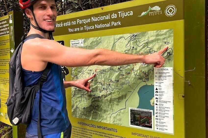 A person pointing to a map at the Tiuca National Park sign. 5