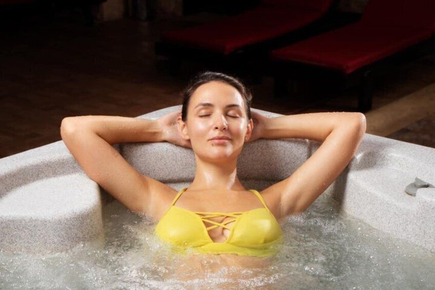A person in a yellow swimsuit relaxing in a hot tub. 4