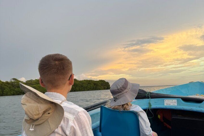 Two people on a boat with a sunset in the background. 5