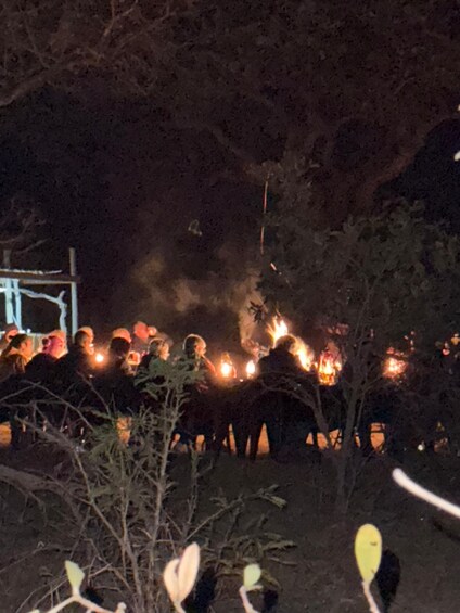 A group of people gathered around a fire at night. 5