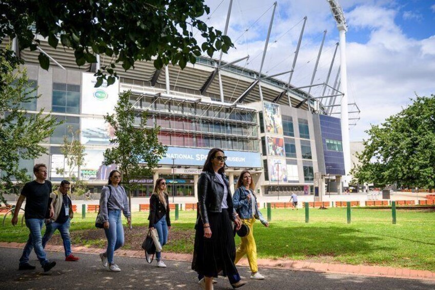 A stadium with a large 'National Stadium' sign, surrounded by a grassy area and trees. 4