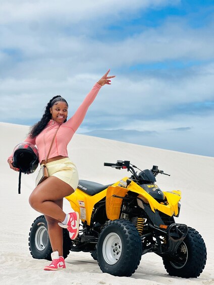 A person on a yellow quad bike in a desert landscape. 2