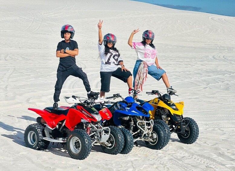 Three people on ATVs in a snowy landscape. 4