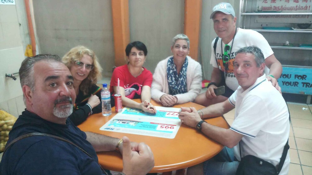 A group of people sitting around a table with a document and a water bottle. 4