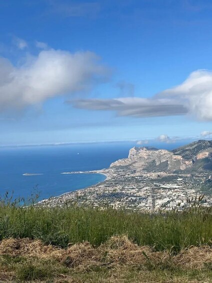 A coastal city with a mountainous backdrop and a clear blue sky. 2
