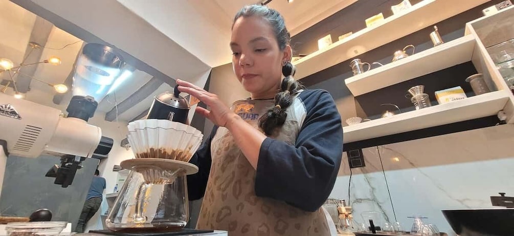 A person operating a coffee machine in a cafe. 1